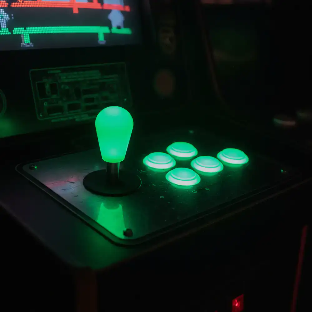 A classic arcade joystick bathed in neon green light.
